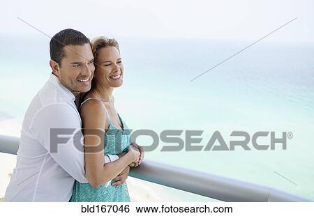 Stock Photograph - Couple hugging on balcony. Fotosearch