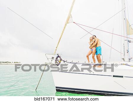 Couple hugging on deck of sailboat View Large Photo Image Stock Image - Couple hugging on deck of sailboat. Fotosearch