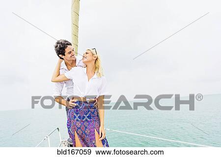 Stock Photo - Couple hugging on deck of sailboat. Fotosearch