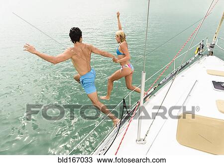Couple jumping from sailboat deck into ocean View Large Photo Image Stock Image - Couple jumping from sailboat deck into ocean. Fotosearch