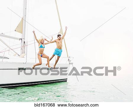 Couple jumping from sailboat View Large Photo Image Stock Photo - Couple jumping from sailboat. Fotosearch