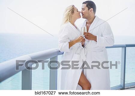 Couple kissing with champagne on balcony View Large Photo Image Stock Photo - Couple kissing with champagne on balcony. Fotosearch