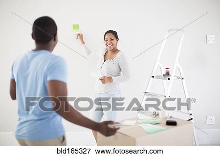 Stock Photo - Couple painting room in new home. Fotosearch