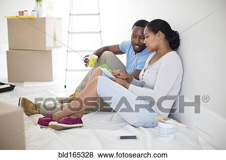 Stock Photo - Couple painting room in new home. Fotosearch