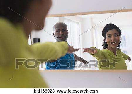 Couple practicing yoga in mirror View Large Photo Image Stock Image - Couple practicing yoga in mirror. Fotosearch