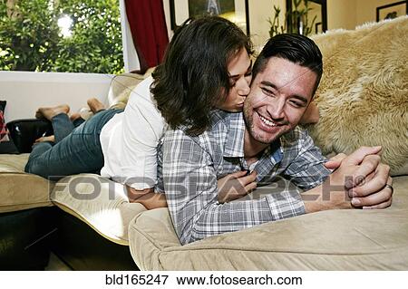 Stock Photo - Couple relaxing on sofa in living room. Fotosearch