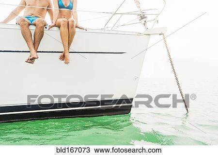 Couple sitting on deck of sailboat View Large Photo Image Stock Image - Couple sitting on deck of sailboat. Fotosearch