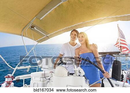 Picture - Couple steering boat on ocean. Fotosearch
