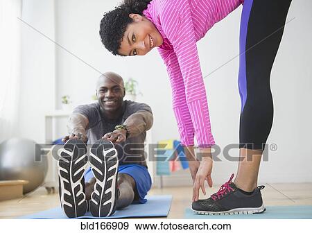 Stock Photo - Couple stretching in gym. Fotosearch