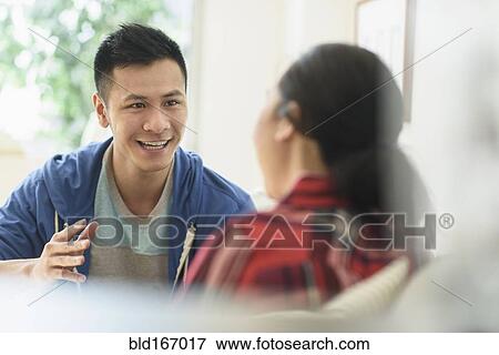 Couple talking on sofa in living room View Large Photo Image Stock Photo - Couple talking on sofa in living room. Fotosearch