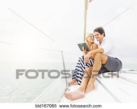 Stock Photography - Couple using digital tablet boat deck. Fotosearch