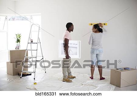 Couple using level in new home View Large Photo Image Stock Image - Couple using level in new home. Fotosearch