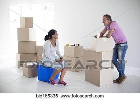 Couple with cardboard boxes in new home View Large Photo Image Stock Photography - Couple with cardboard boxes in new home. Fotosearch