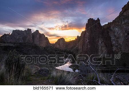 Stock Image - Creek reflecting sunset sky in desert landscape, Smith Rock State Park, Oregon, United States. Fotosearch
