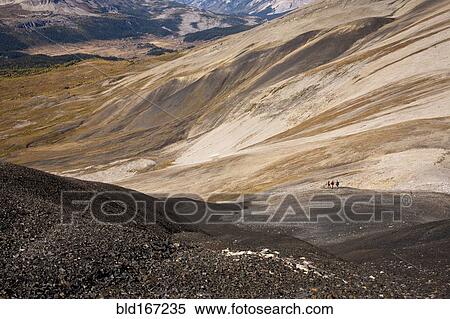 Stock Photography - Distant view of hikers walking on remote hillside. Fotosearch