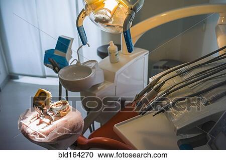 Stock Image - Empty chair and dentures in office of dentist. Fotosearch