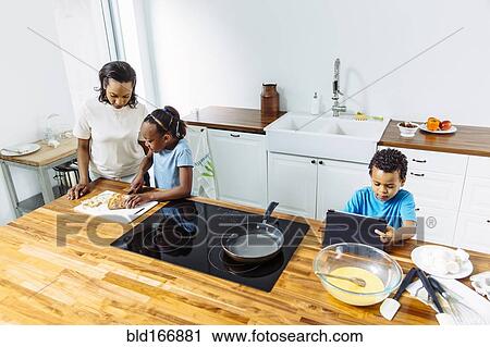 Family cooking breakfast together in kitchen View Large Photo Image Stock Image - Family cooking breakfast together in kitchen. Fotosearch