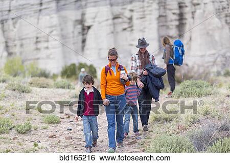 Stock Photograph - Family hiking on dirt path. Fotosearch