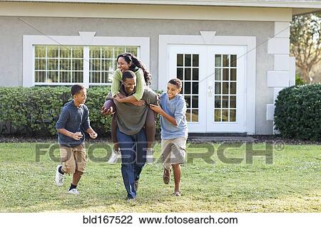 Family playing football in backyard View Large Photo Image Stock Image - Family playing football in backyard. Fotosearch