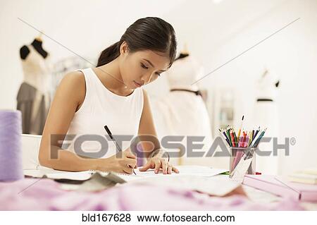 Stock Photo - Fashion designer drawing in studio. Fotosearch