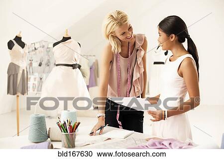 Stock Image - Fashion designers working together in studio. Fotosearch