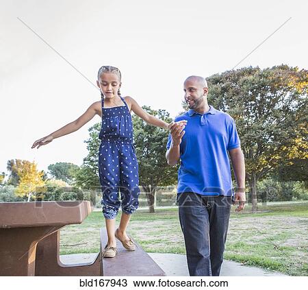 Father and daughter playing on picnic table in park View Large Photo Image Stock Image - Father and daughter playing on picnic table in park. Fotosearch