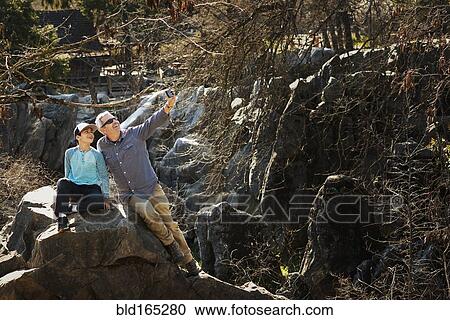 Stock Image - Father and son taking selfie in forest. Fotosearch