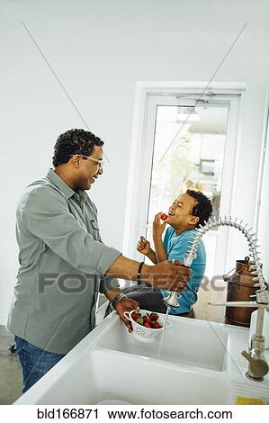 Father and son washing strawberries in kitchen sink View Large Photo Image Stock Image - Father and son washing strawberries in kitchen sink. Fotosearch