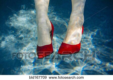 Stock Photo - Feet of woman wearing high heels in swimming pool. Fotosearch