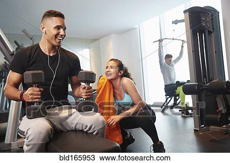 Stock Image - Friends working out in gym. Fotosearch