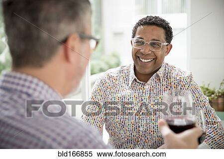 Stock Photography - Gay couple toasting with wine. Fotosearch