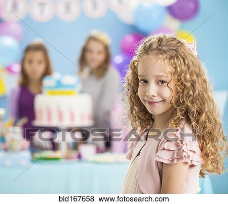 Stock Photo - Girl smiling at birthday party. Fotosearch