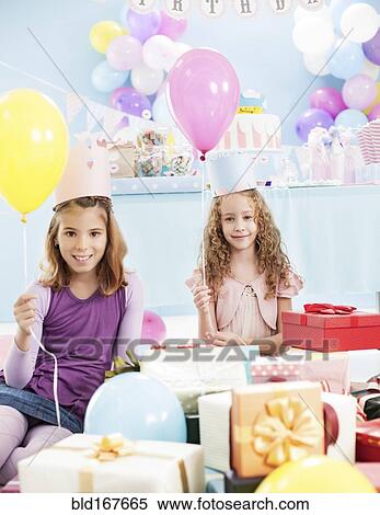 Girls holding balloons at birthday party View Large Photo Image Stock Photography - Girls holding balloons at birthday party. Fotosearch