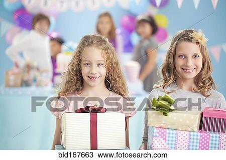 Girls holding wrapped gifts at birthday party View Large Photo Image Stock Image - Girls holding wrapped gifts at birthday party. Fotosearch