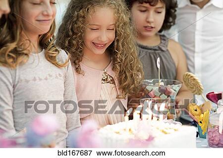Girls looking at birthday cake at party View Large Photo Image Stock Photo - Girls looking at birthday cake at party. Fotosearch