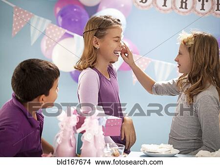 Girls playing with birthday cake at party View Large Photo Image Picture - Girls playing with birthday cake at party. Fotosearch