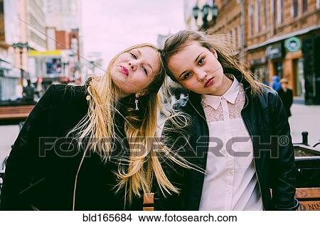 Picture - Girls standing together in city. Fotosearch