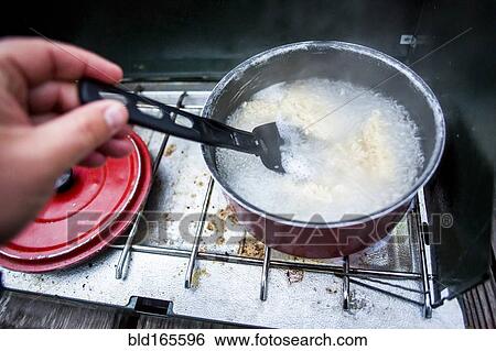 Hand stirring pot on campsite stove View Large Photo Image Stock Photograph - Hand stirring pot on campsite stove. Fotosearch