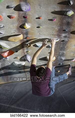 High angle view of athlete climbing rock wall in gym View Large Photo Image Stock Image - High angle view of athlete climbing rock wall in gym. Fotosearch