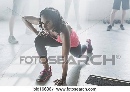 Stock Photo - High angle view of athlete stretching in gym. Fotosearch
