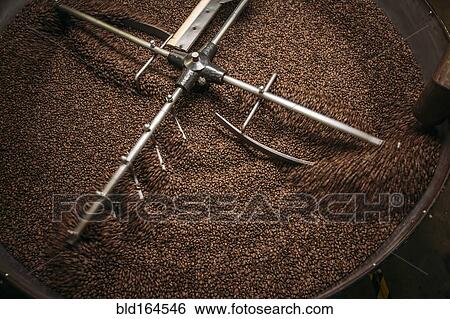 Stock Photograph - High angle view of equipment and beans in coffee roaster. Fotosearch