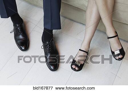 Stock Photo - High angle view of legs of business people sitting on sofa. Fotosearch