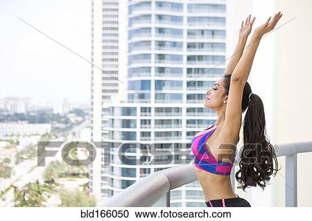 Hispanic athlete stretching on balcony View Large Photo Image Stock Image - Hispanic athlete stretching on balcony. Fotosearch