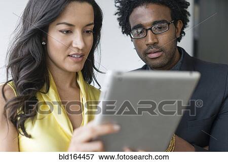 Stock Photo - Hispanic business people using digital tablet. Fotosearch