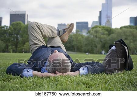 Hispanic businessman laying on grass in urban park, New York, New York, United States View Large Photo Image Stock Image - Hispanic businessman laying on grass in urban park, New York, New York, United States. Fotosearch