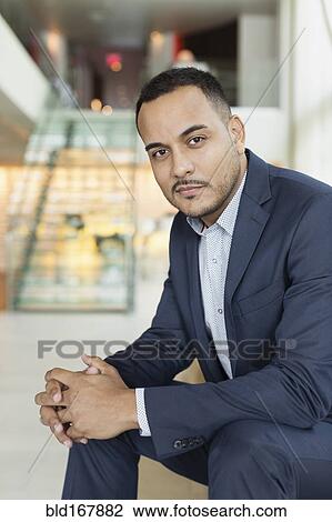 Hispanic businessman sitting in hotel lobby View Large Photo Image Stock Image - Hispanic businessman sitting in hotel lobby. Fotosearch