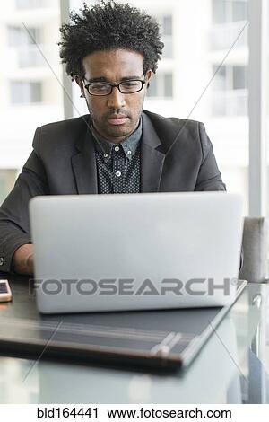 Hispanic businessman using laptop in office View Large Photo Image Stock Image - Hispanic businessman using laptop in office. Fotosearch