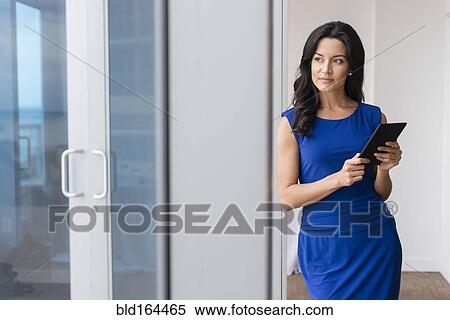 Stock Photography - Hispanic businesswoman using digital tablet in office. Fotosearch
