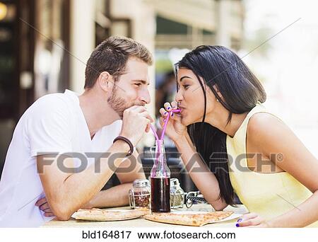 Stock Photo - Hispanic couple drinking soda at cafe. Fotosearch