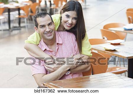 Hispanic couple hugging at sidewalk cafe View Large Photo Image Stock Image - Hispanic couple hugging at sidewalk cafe. Fotosearch